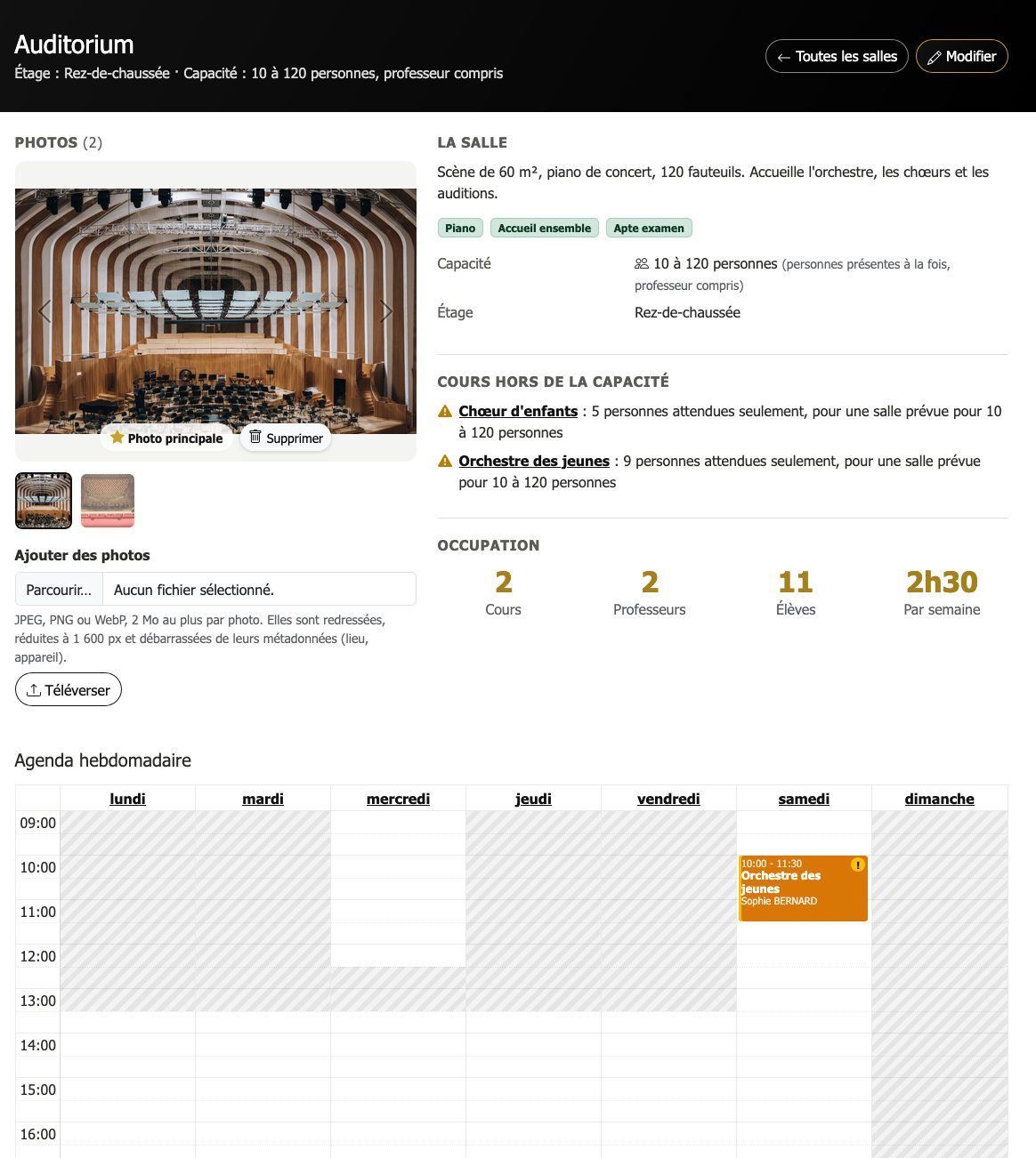 Page de l'auditorium : carrousel de photos avec la photo principale, capacité de 10 à 120 personnes, professeur compris, deux cours signalés sous le minimum (5 et 9 personnes attendues), chiffres d'occupation et agenda grisé hors des horaires d'ouverture.