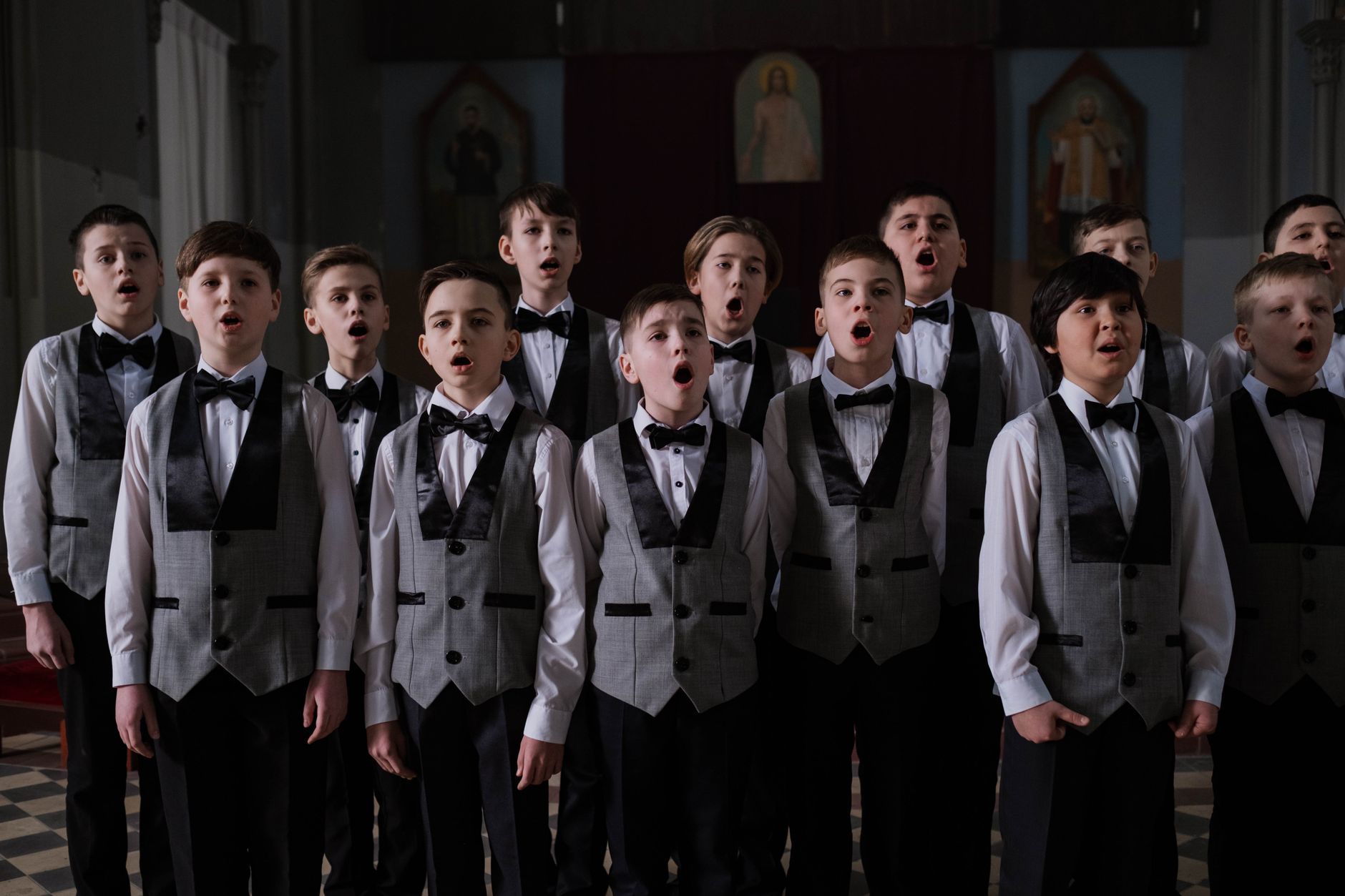Un chœur en pleine interprétation d'une œuvre sacrée contemporaine, sous la direction d'un chef d'orchestre.